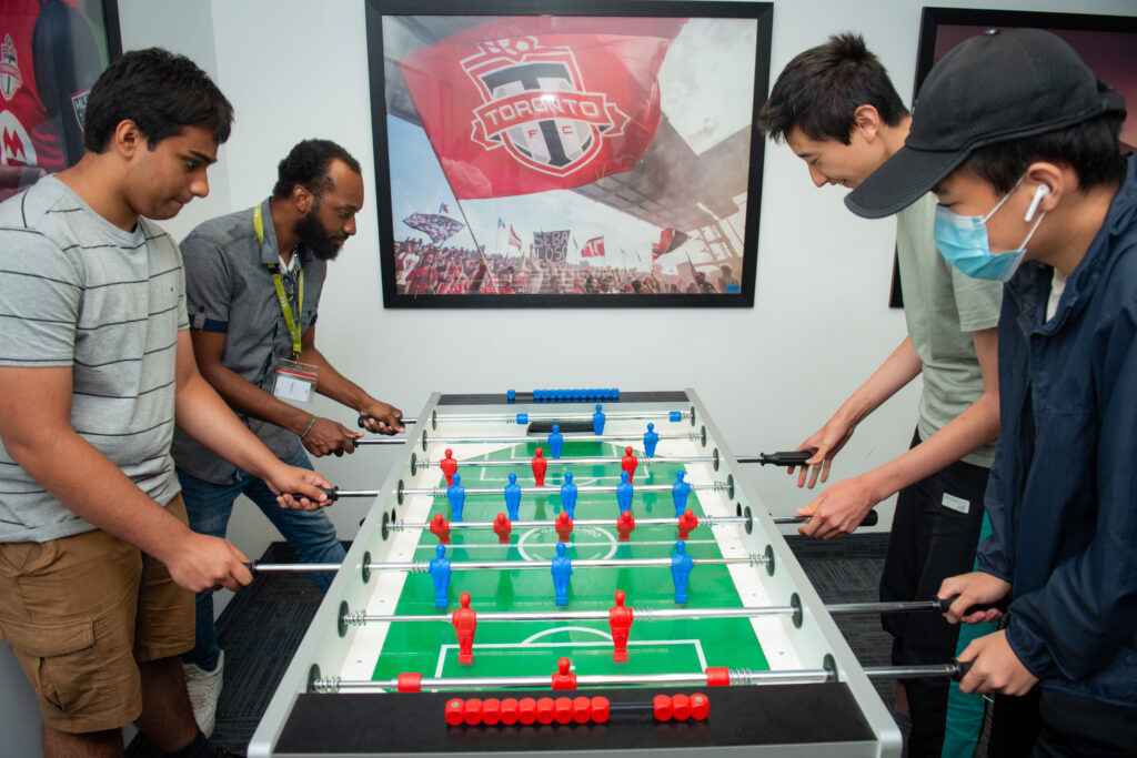 Youth and staff playing foosball