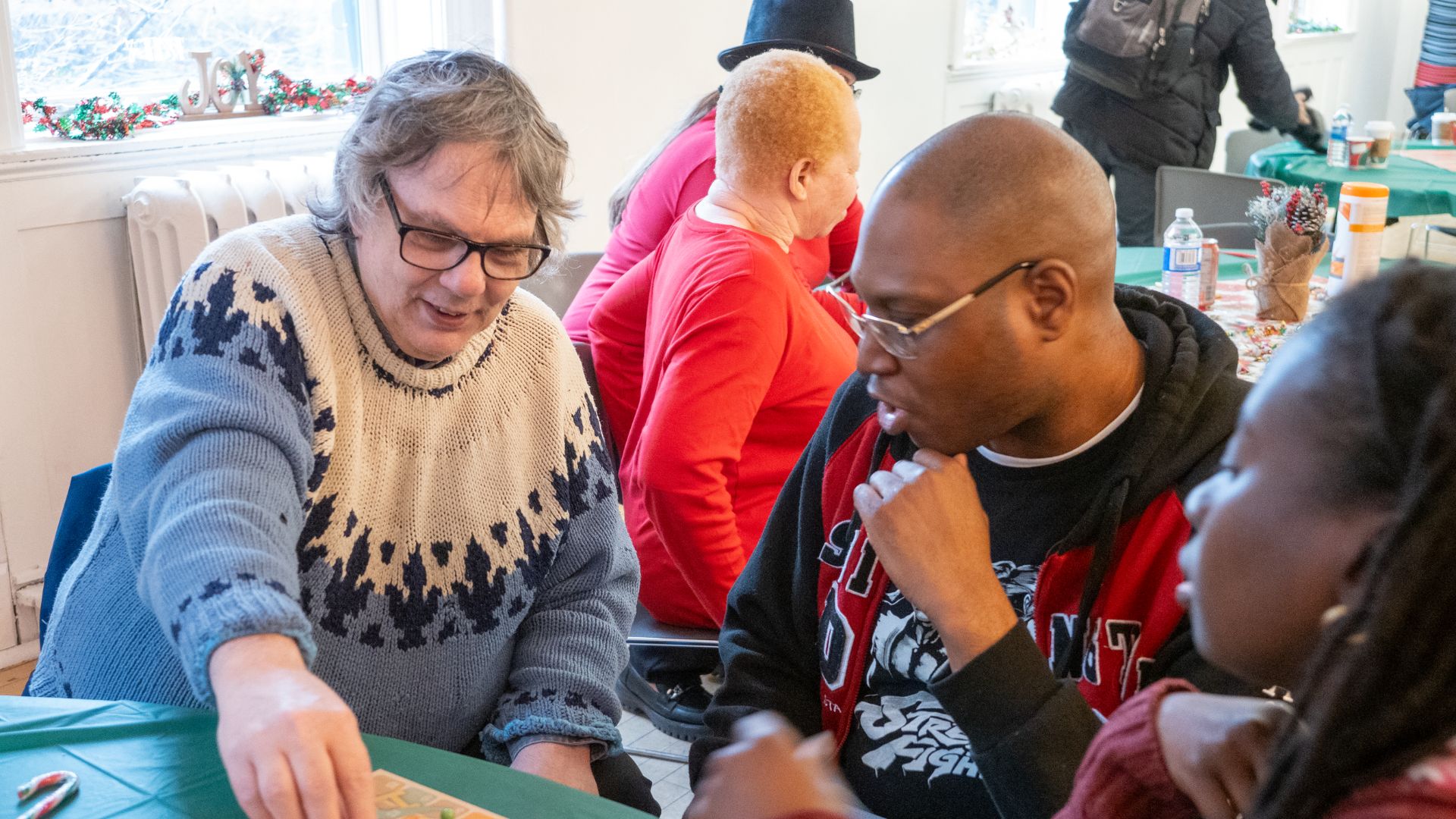 WoodGreen clients play a board game at a holiday event