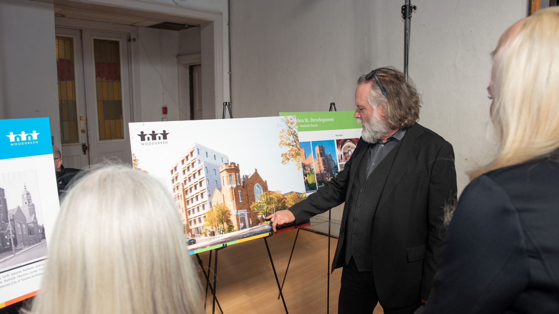 Man points to a rendering of an upcoming WoodGreen development