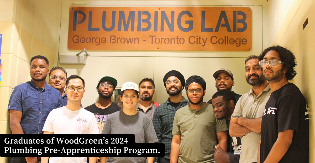 A group stands in front of a sign for the George Brown Plumbing Lab